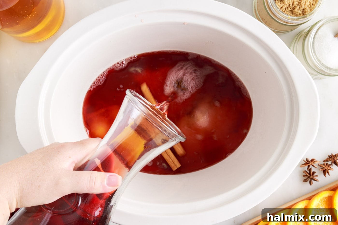 Warm Cranberry Elixir 6 Pouring juices into hot cranberry punch in the crockpot