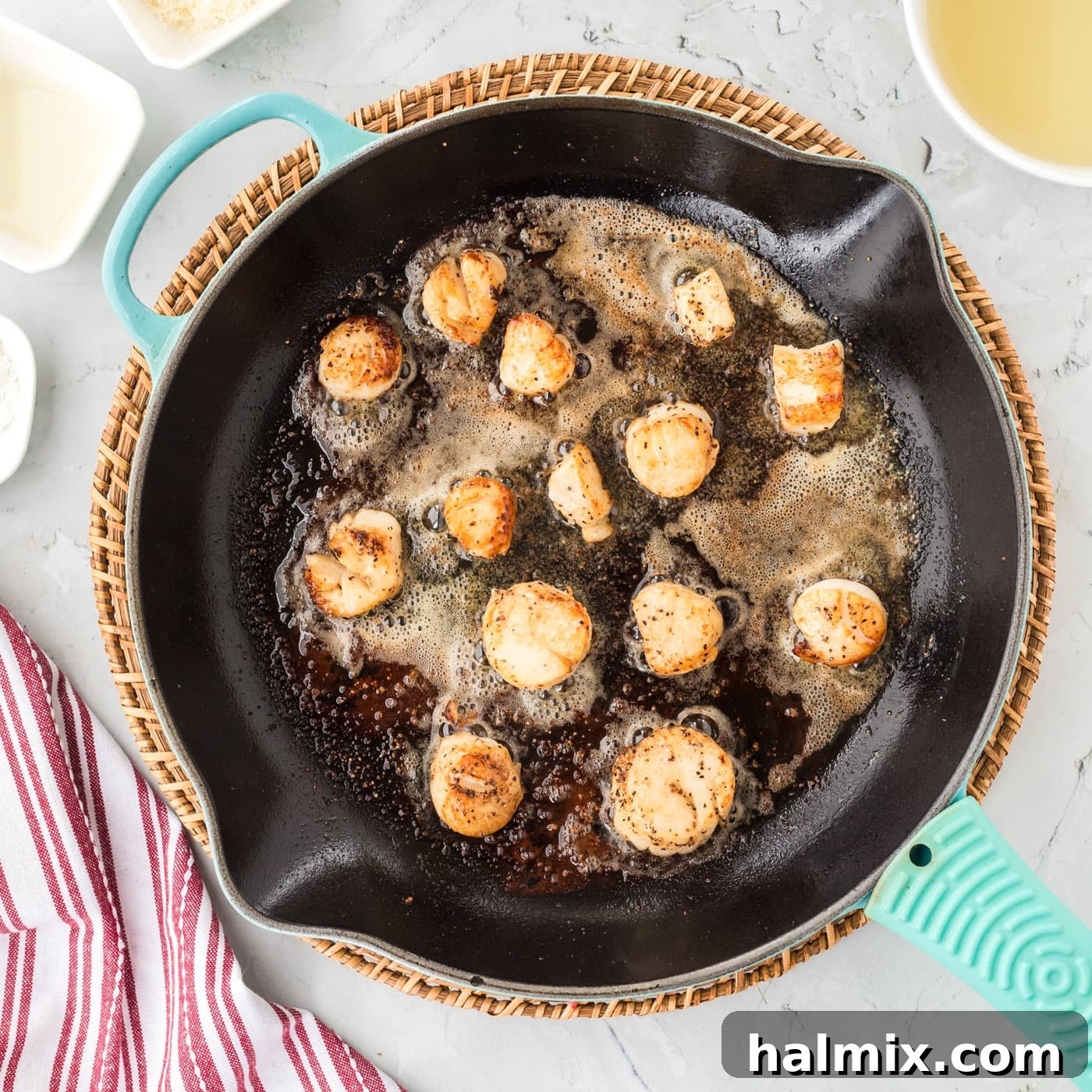 Golden-brown pan-seared scallops cooking in foaming butter in a skillet