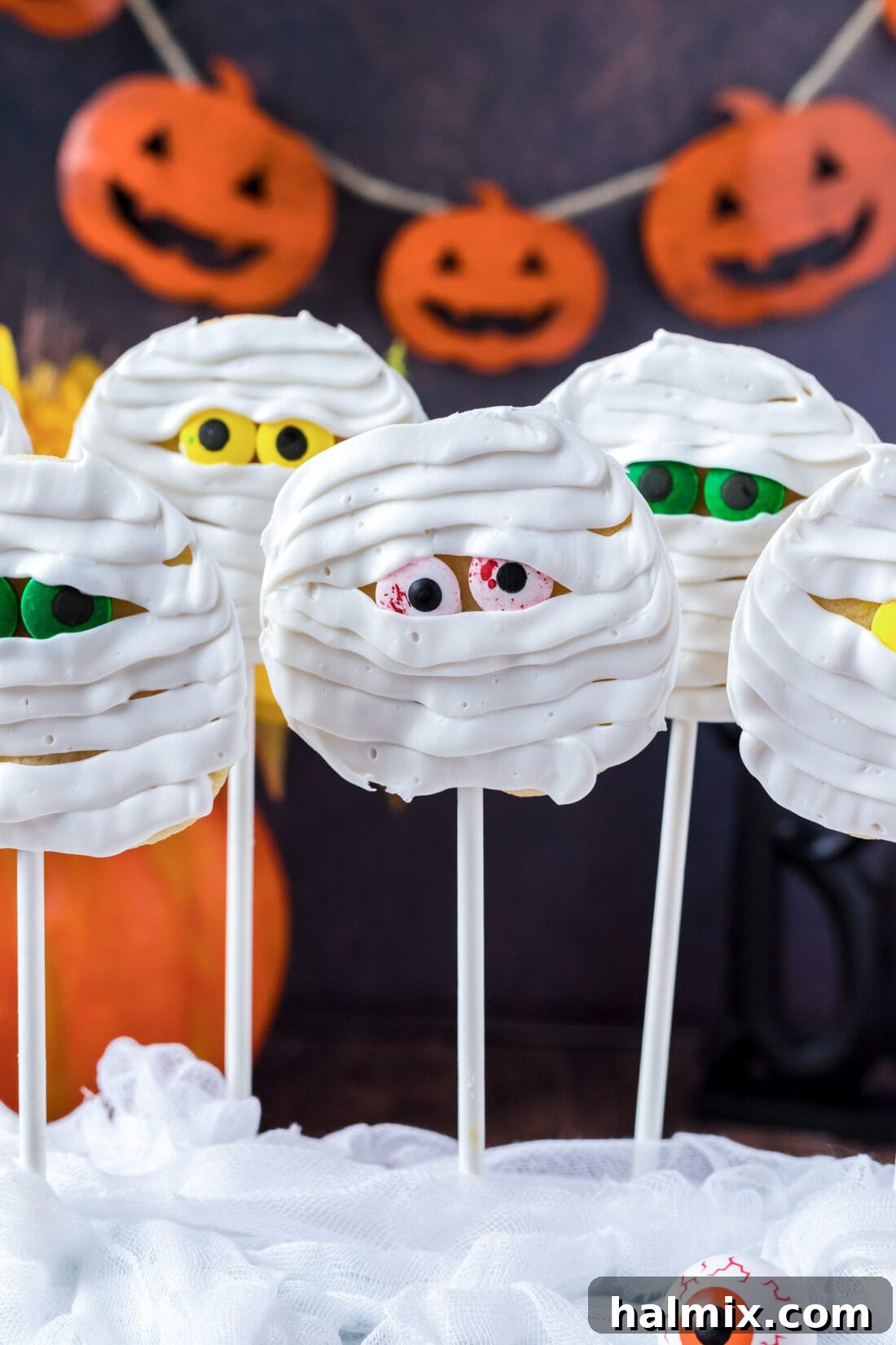 Delicious Mummy Cookies with a Halloween pumpkin banner in the background