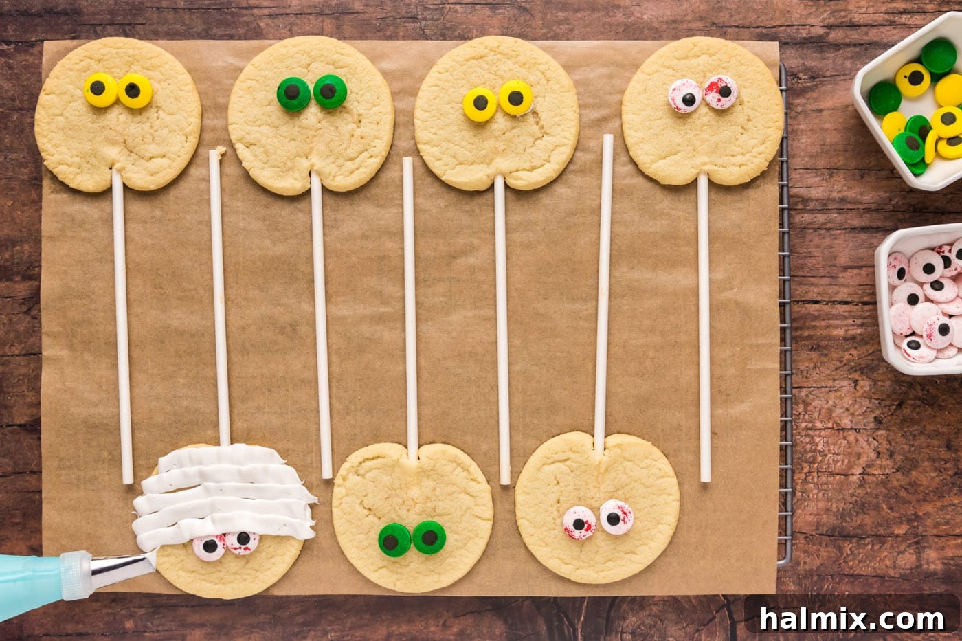 Decorating cookies with candy eyeballs and piped frosting bandages