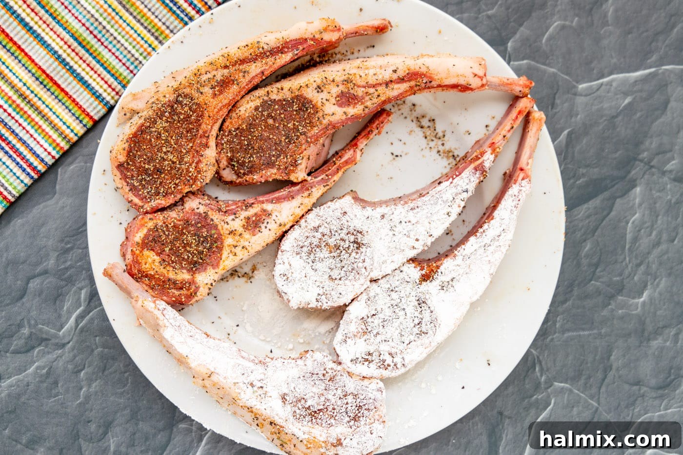A seasoned lamb chop being coated evenly in all-purpose flour on a plate, preparing it for a perfect sear.
