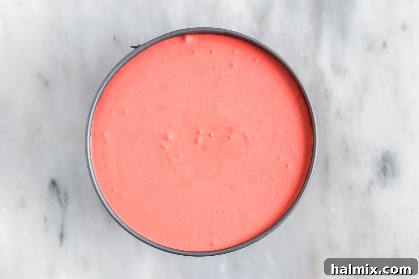 The final red layer of jello pie added, completing the festive three-layered dessert in the springform pan.