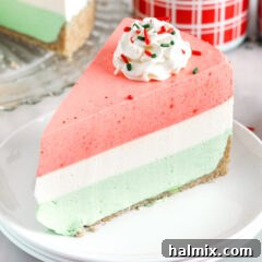 Layered Jello Pie on a plate with a slice removed, showing off its beautiful layers.