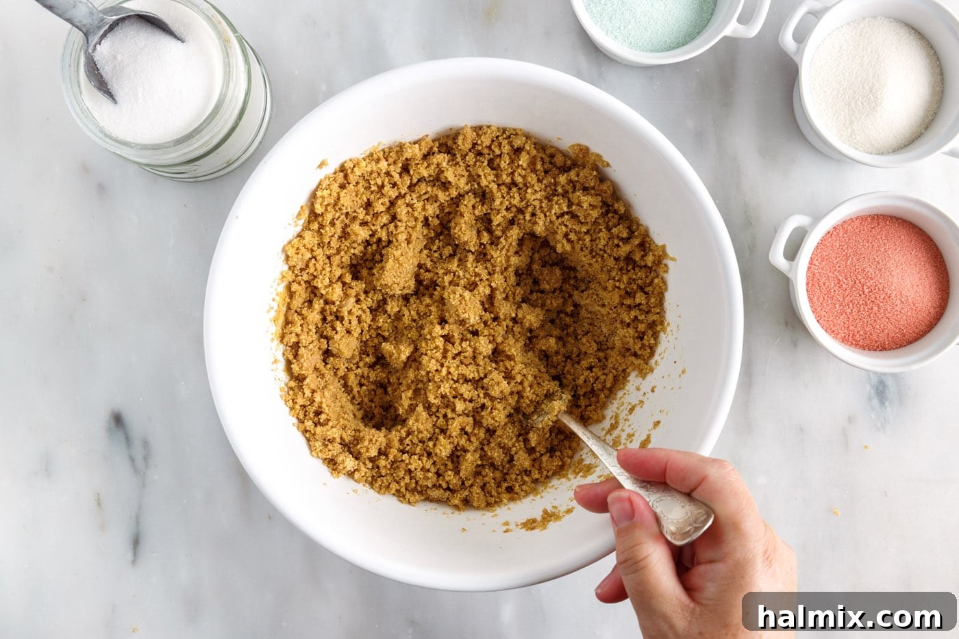 Rainbow Ripple Gelatin Pie 5 Mixing graham cracker crumbs with melted butter and sugar in a bowl to form the pie crust.