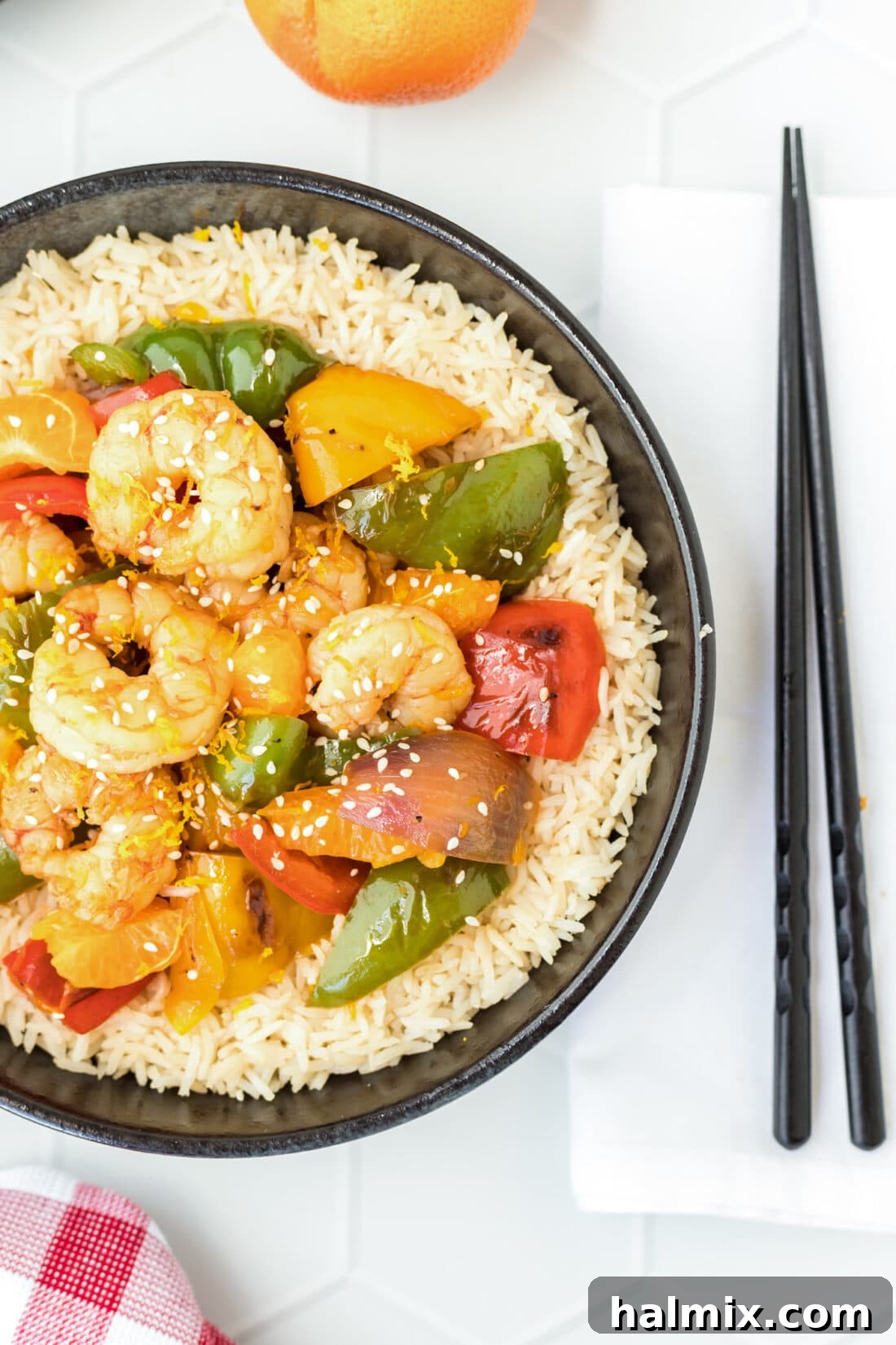 A vibrant plate of Clementine Pepper Shrimp, garnished with fresh herbs, ready to be served over rice or enjoyed as a standalone dish.
