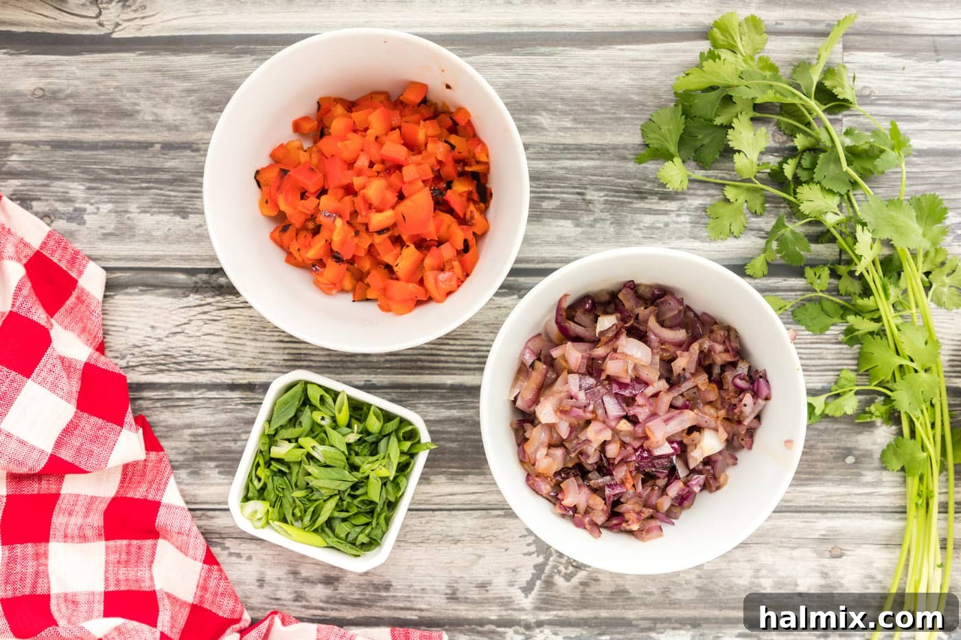 Diced red bell pepper, red onion, and green onion in separate bowls
