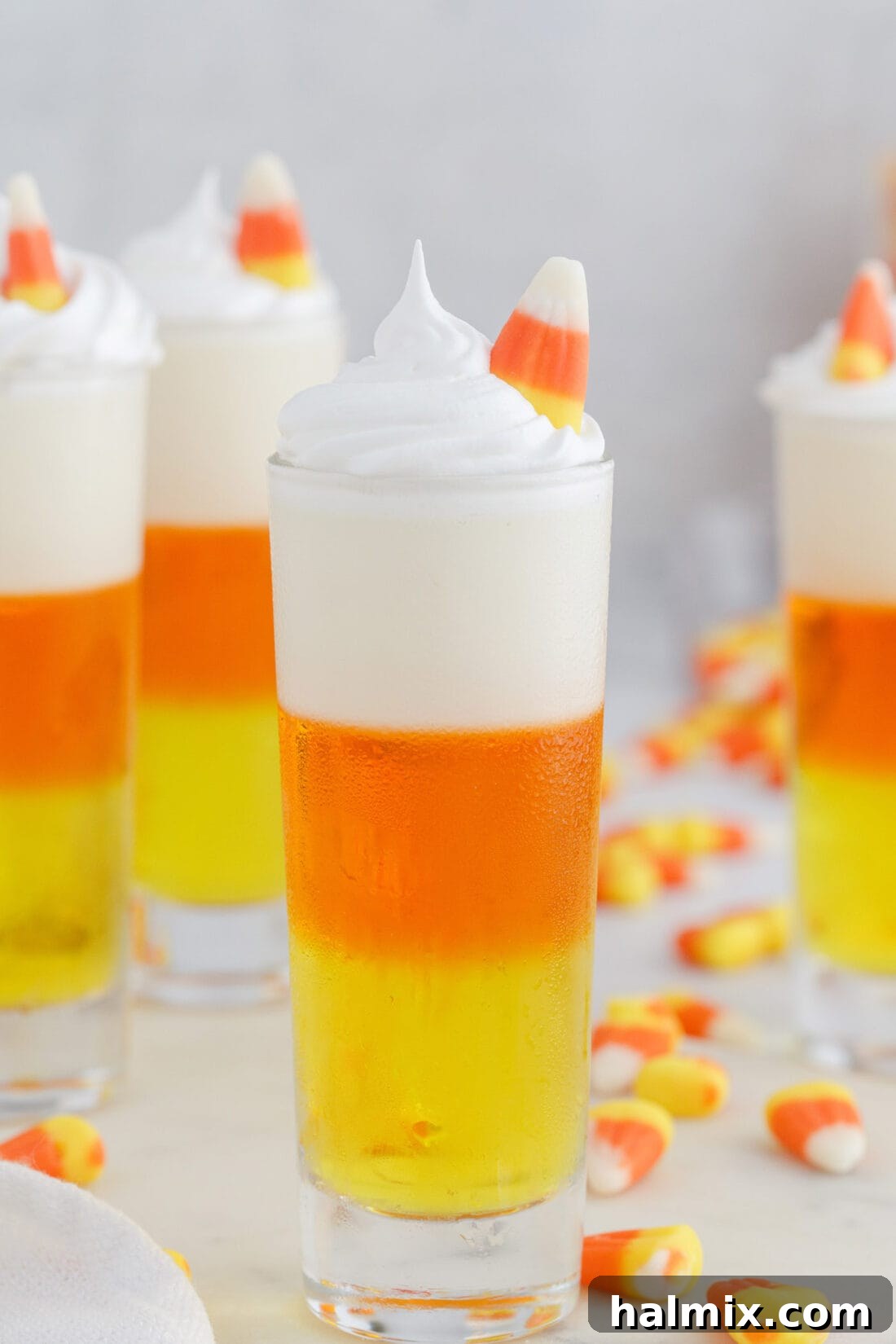 Vibrant Candy Corn Jello Shots with a classic candy corn on top, ready for a Halloween party.