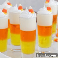 Candy Corn Jello Shots garnished with whip cream and a candy corn