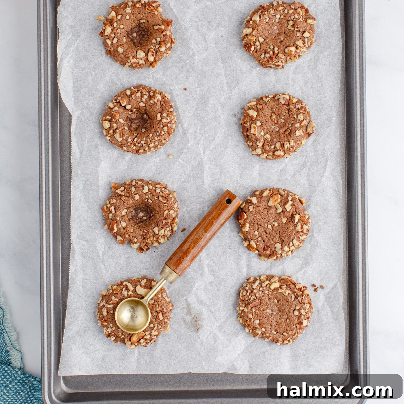 measuring spoon creating indents in thumbprint cookies
