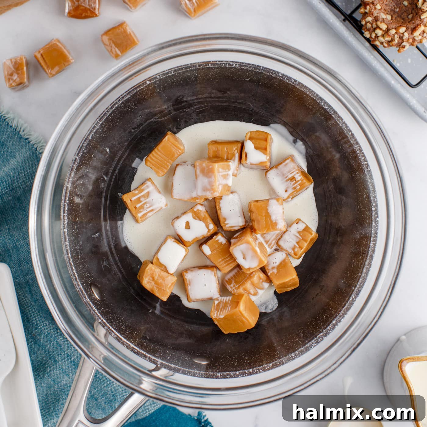 caramels and heavy cream in a bowl over a saucepan