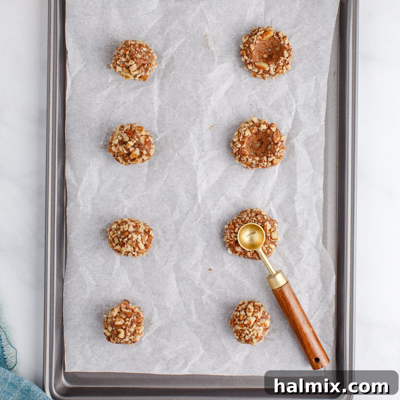 pressing turtle thumbprint cookies with a measuring spoon
