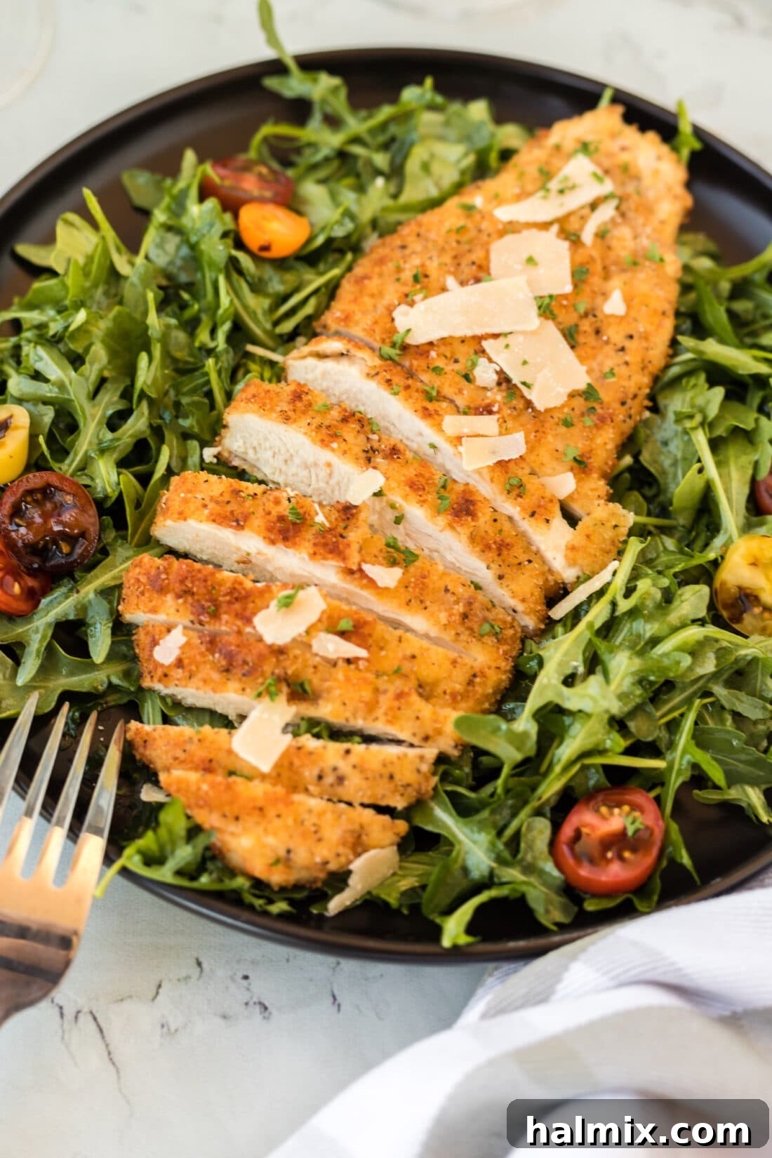 Crispy Golden Milanese Chicken 2 Crispy golden Chicken Milanese on a plate with fresh greens, ready to be served