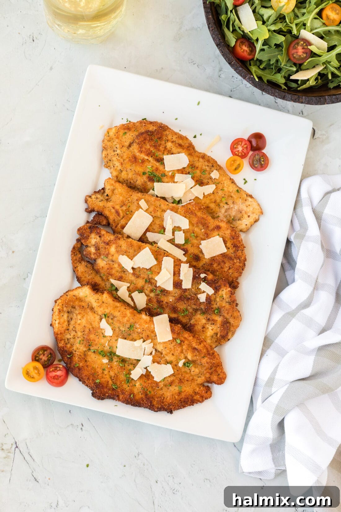 Crispy Golden Milanese Chicken 3 A beautiful platter of golden-brown Chicken Milanese cutlets, garnished and ready for serving