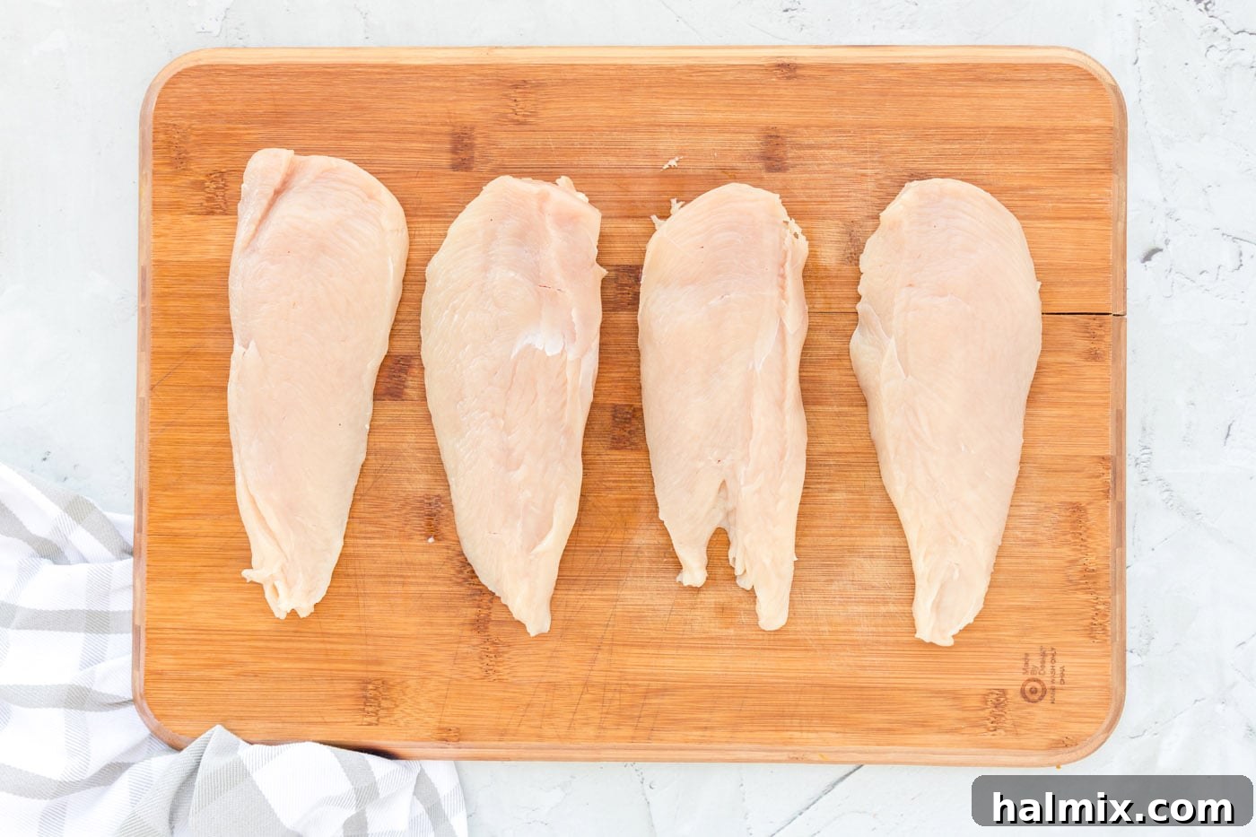 Butterflied and sliced chicken breasts laid out on a cutting board