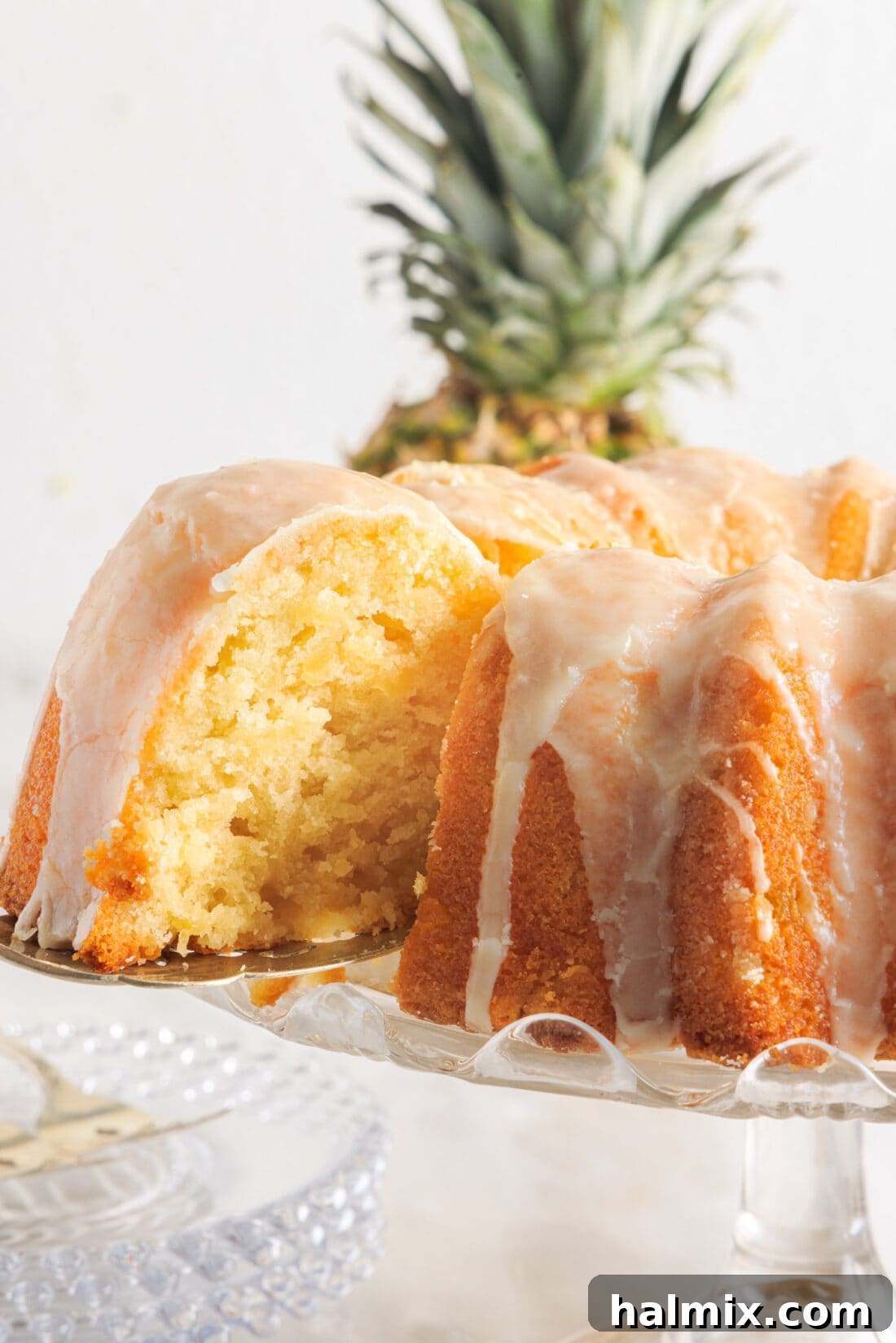 Luscious Pineapple Pound Cake 2 A beautifully sliced Pineapple Pound Cake, revealing its moist interior, with a sweet vanilla glaze drizzled over the top. Perfect for any occasion.