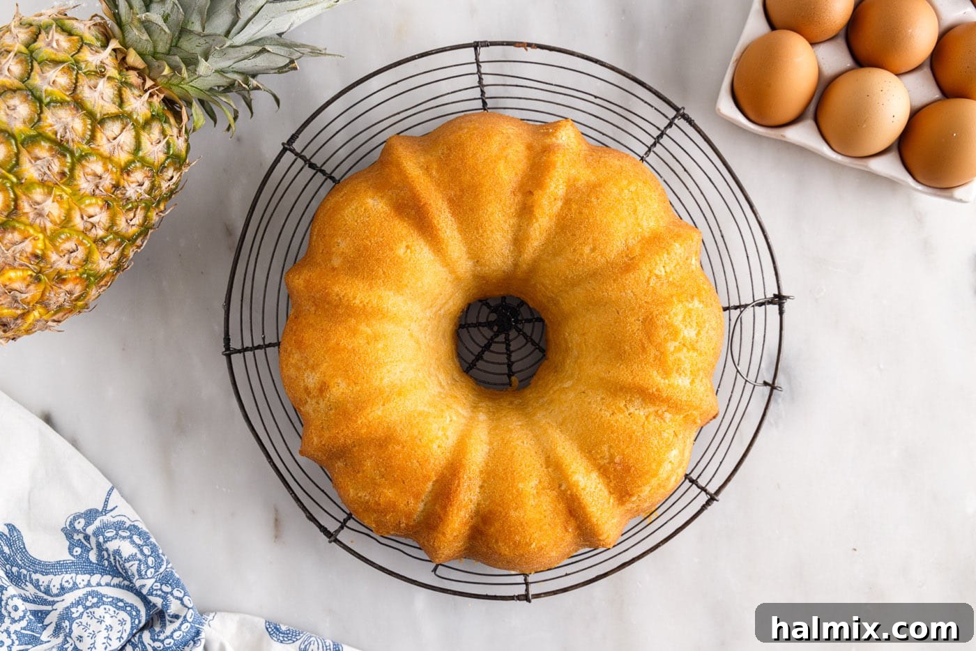 Luscious Pineapple Pound Cake 11 Freshly baked pineapple pound cake cooling on a wire rack after being removed from the bundt pan, allowing air circulation.