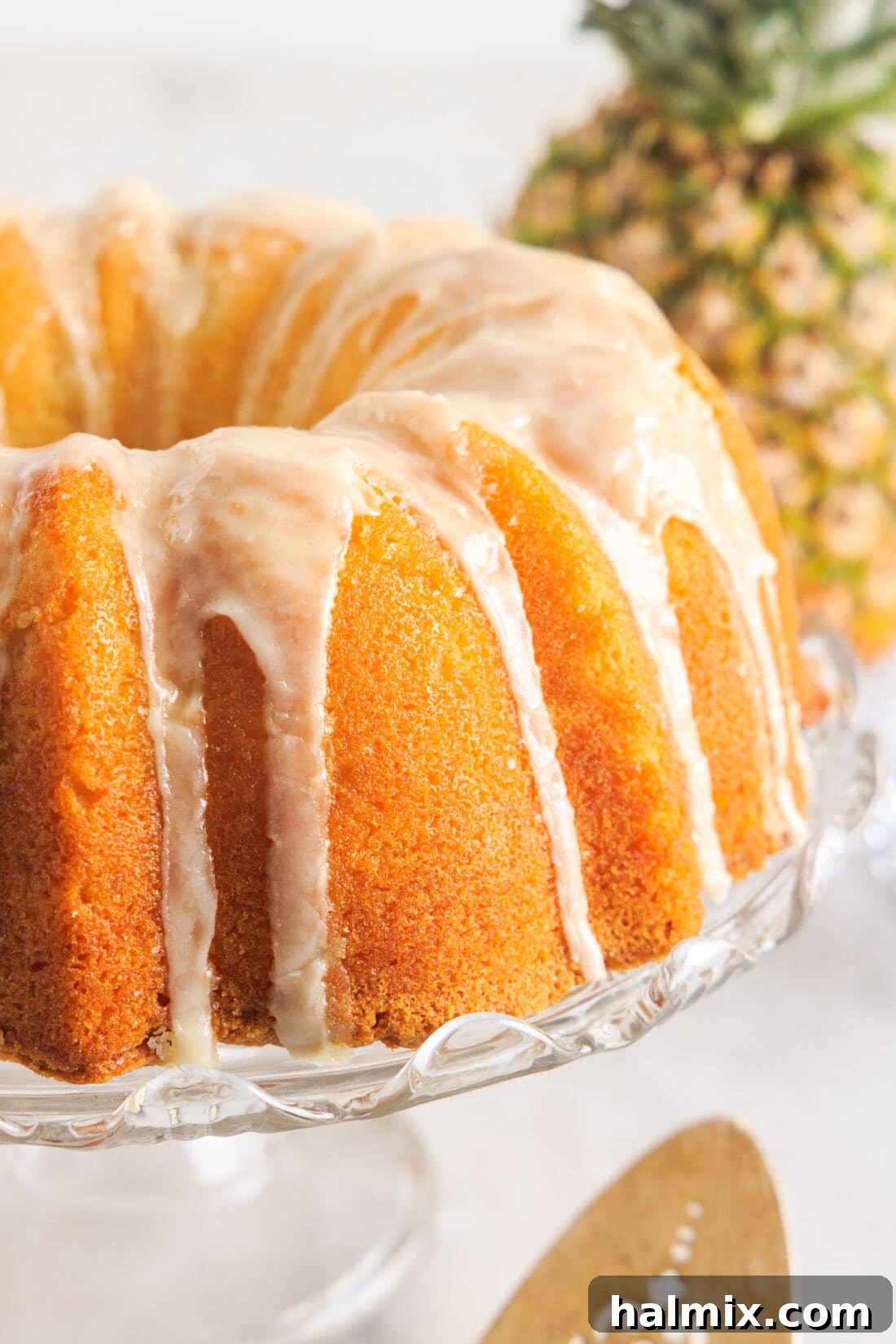 Luscious Pineapple Pound Cake 3 A complete Pineapple Pound Cake resting on an elegant cake plate, ready to be served, showcasing its golden-brown crust and inviting glaze.