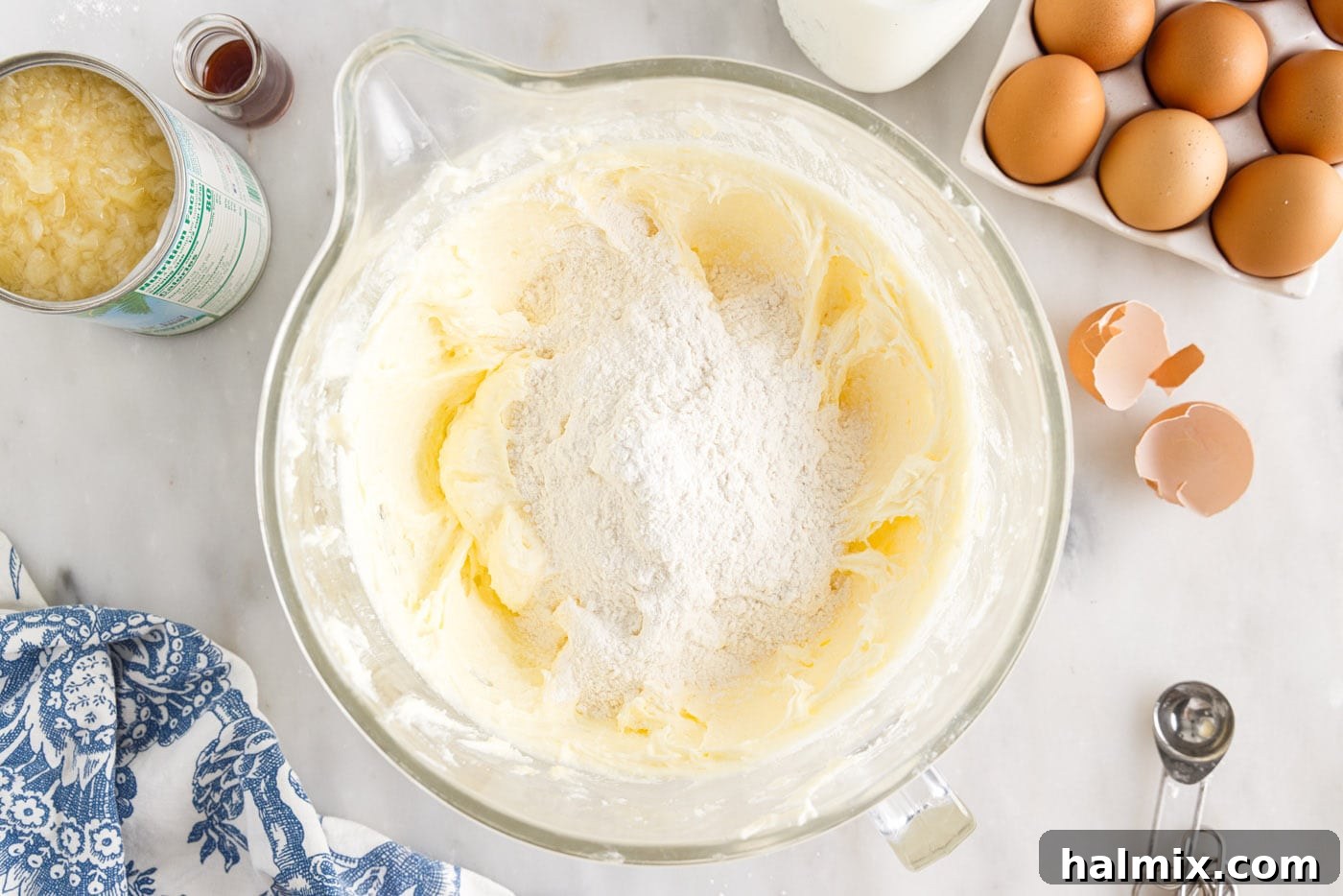 Luscious Pineapple Pound Cake 7 Flour mixture being gently folded into the wet ingredients in a large mixing bowl, ensuring a uniform batter without overmixing.