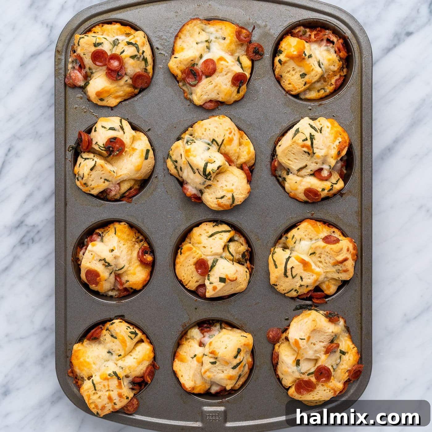 Baked pizza bites fresh out of the oven, still in the muffin pan.