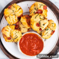 Close-up of baked pizza bites with marinara sauce.