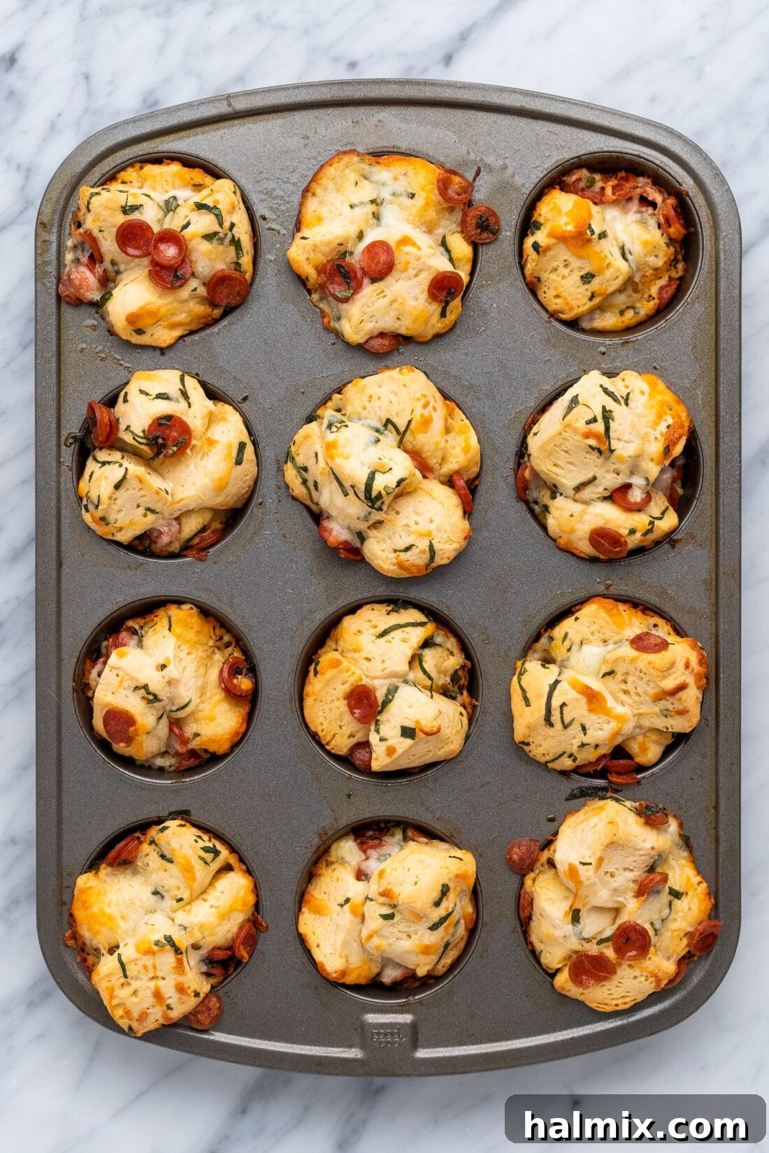 Pizza Zingers 3 A muffin pan filled with baked pizza bites, golden brown and puffed.