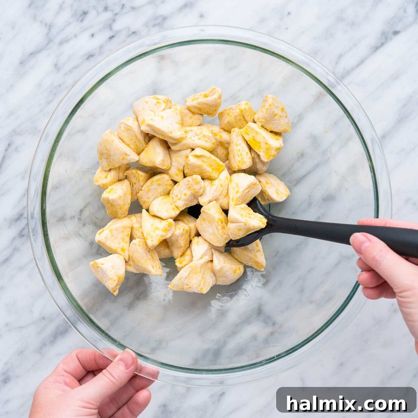 Pizza Zingers 6 Tossing chopped biscuit dough with olive oil in a bowl to coat evenly.