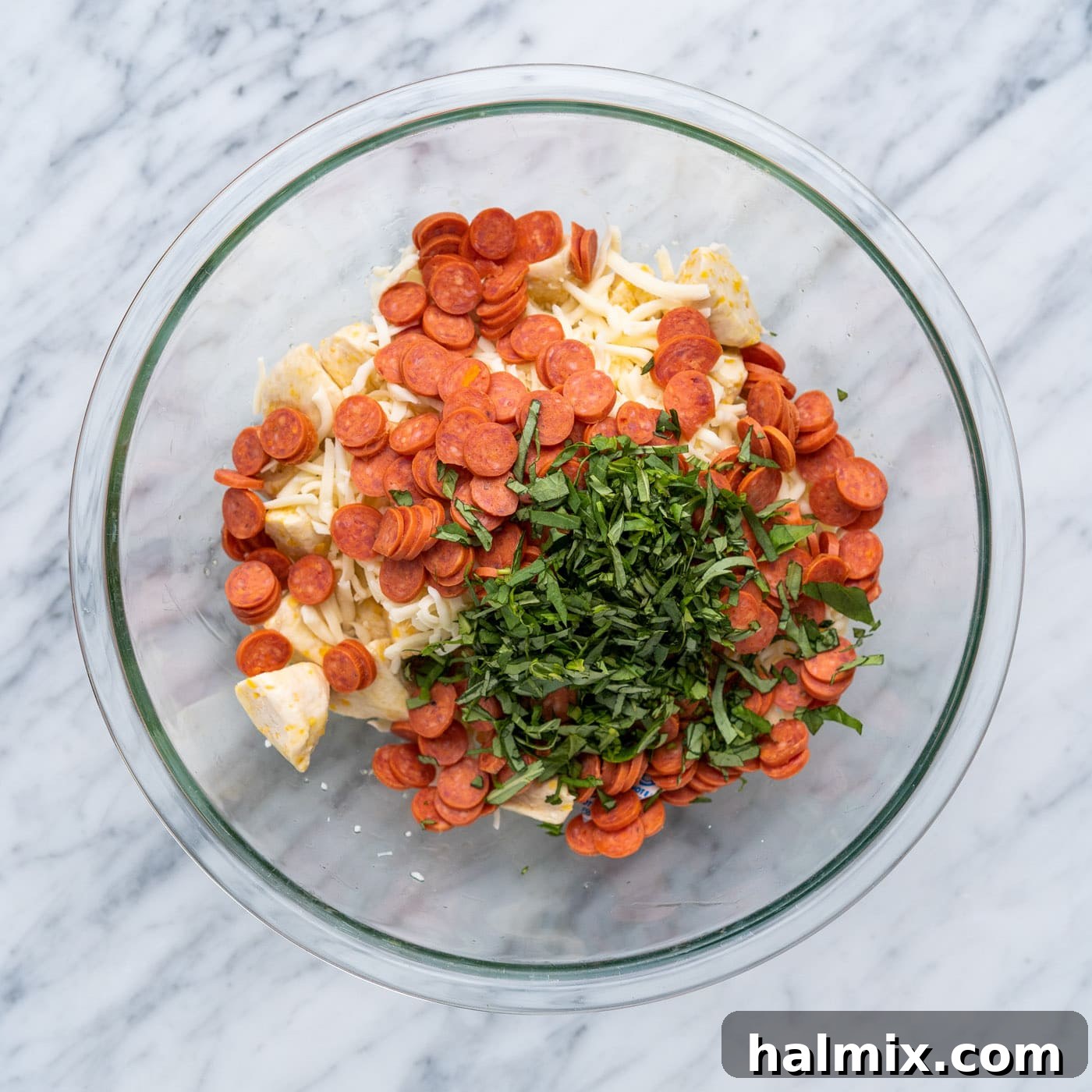 Pizza Zingers 8 Close-up of mini pepperonis, biscuit dough, basil, and mozzarella cheese ready for mixing.