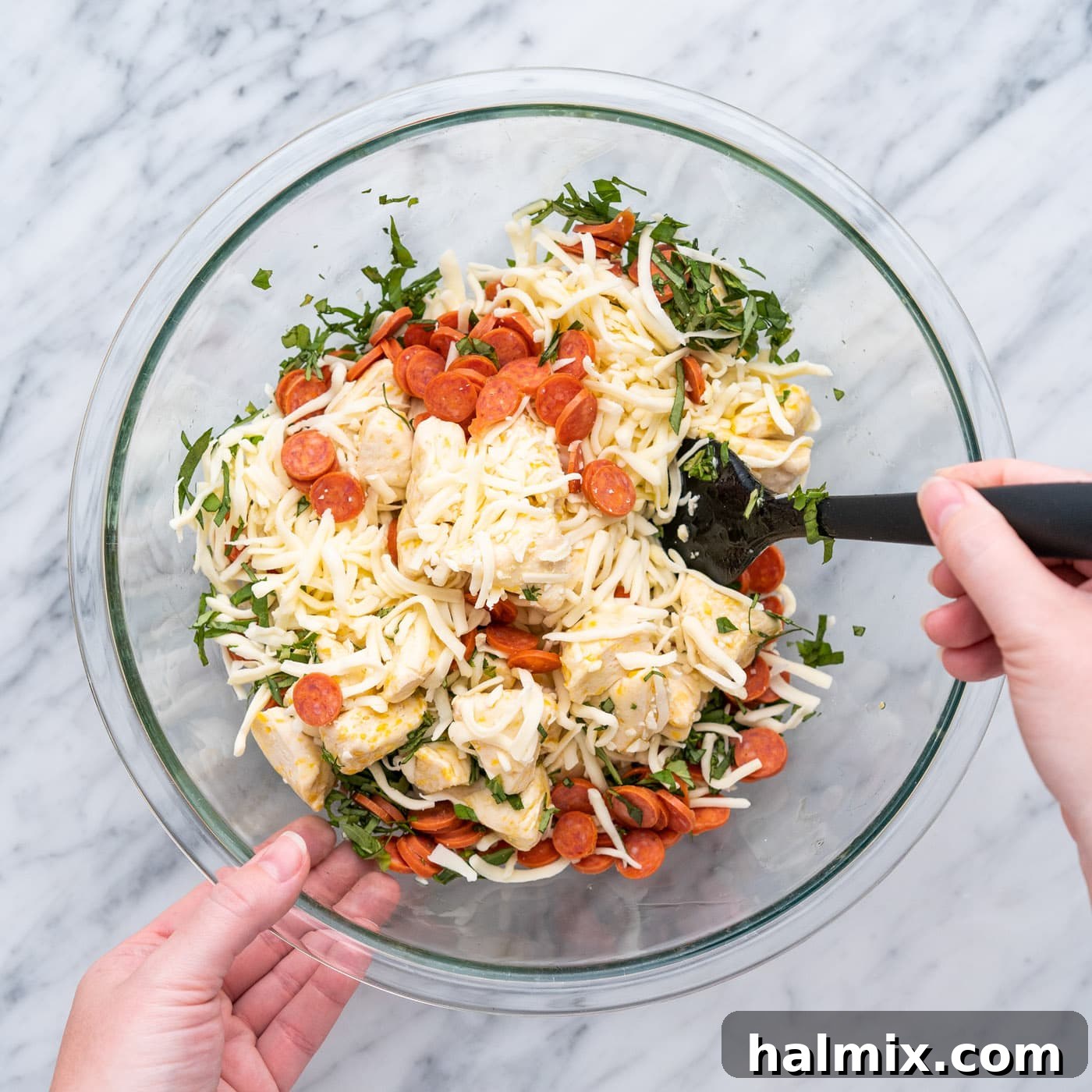 Mixing all pizza bite ingredients thoroughly in a large bowl.