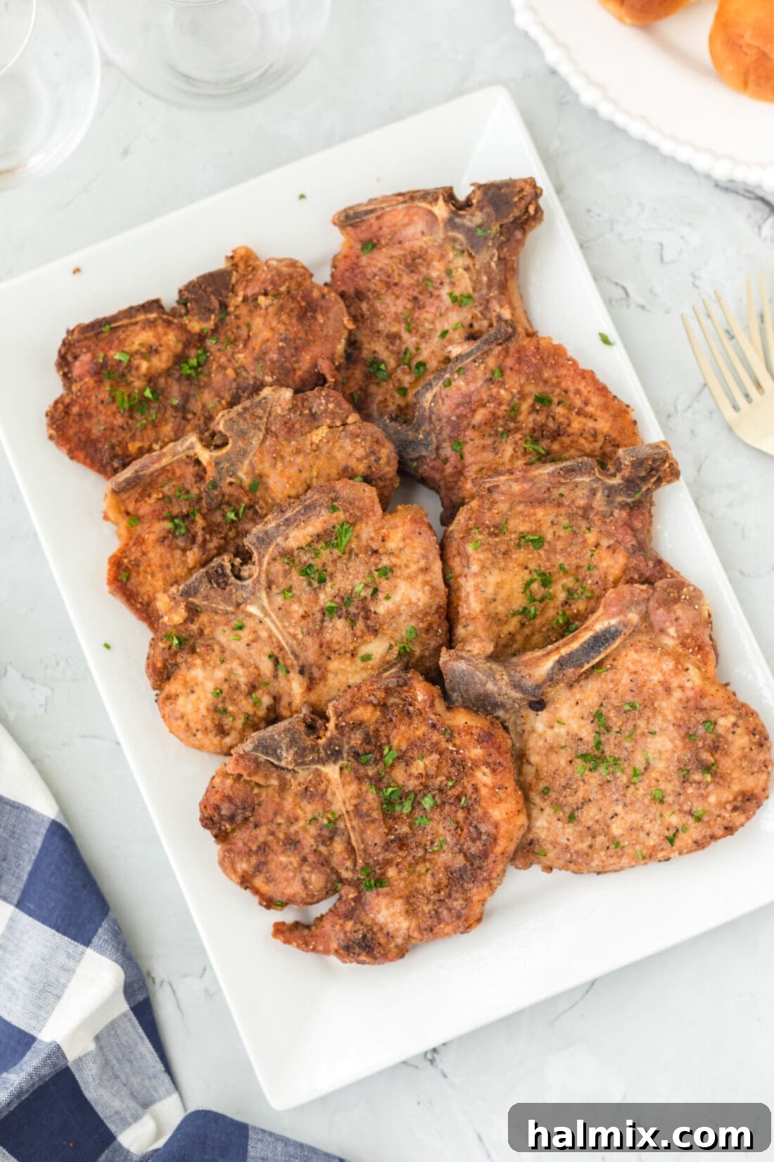 A beautifully plated dish of golden pan-fried pork chops, garnished and ready to enjoy
