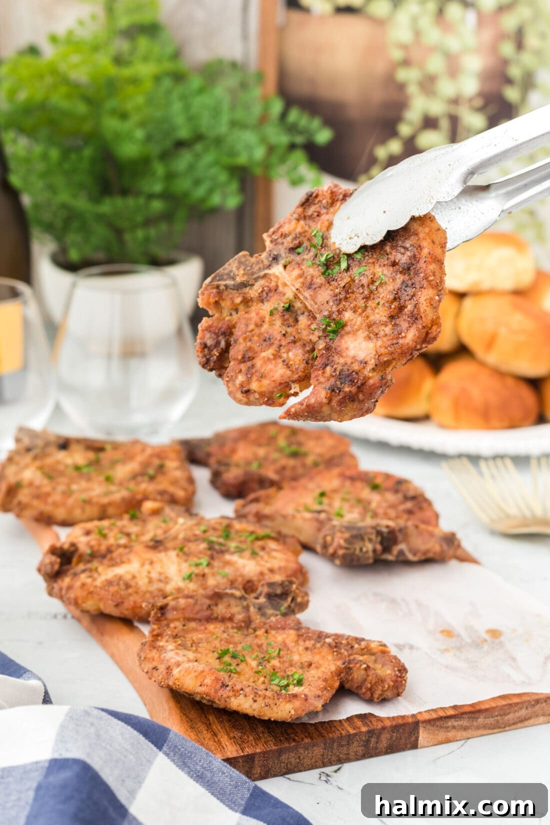Tongs Carefully Lifting a Perfectly Golden Pan-Fried Pork Chop from a Skillet