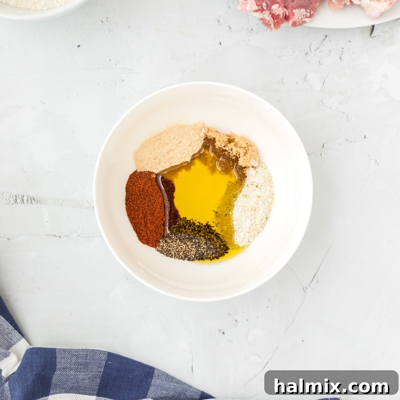 Olive oil and a blend of spices in a bowl, forming a paste for the pork chops