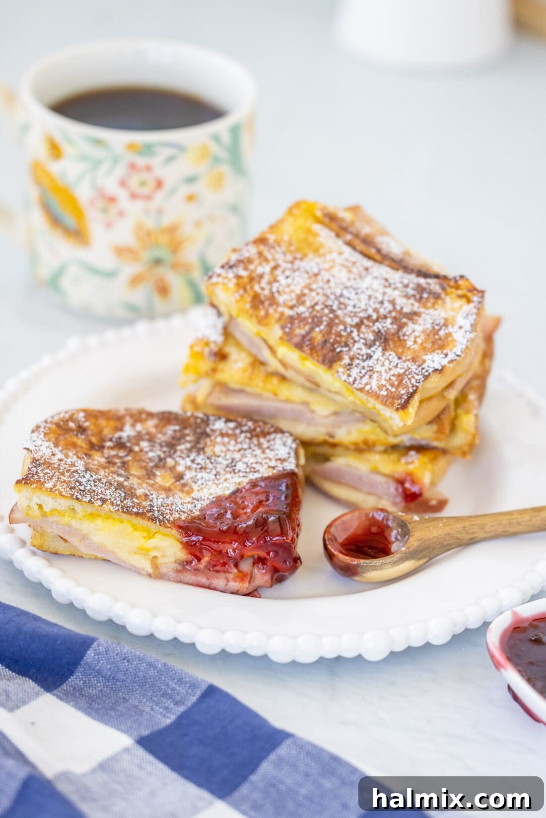 A perfectly cooked Monte Cristo Sandwich, beautifully presented with a generous dollop of raspberry jam on the side.