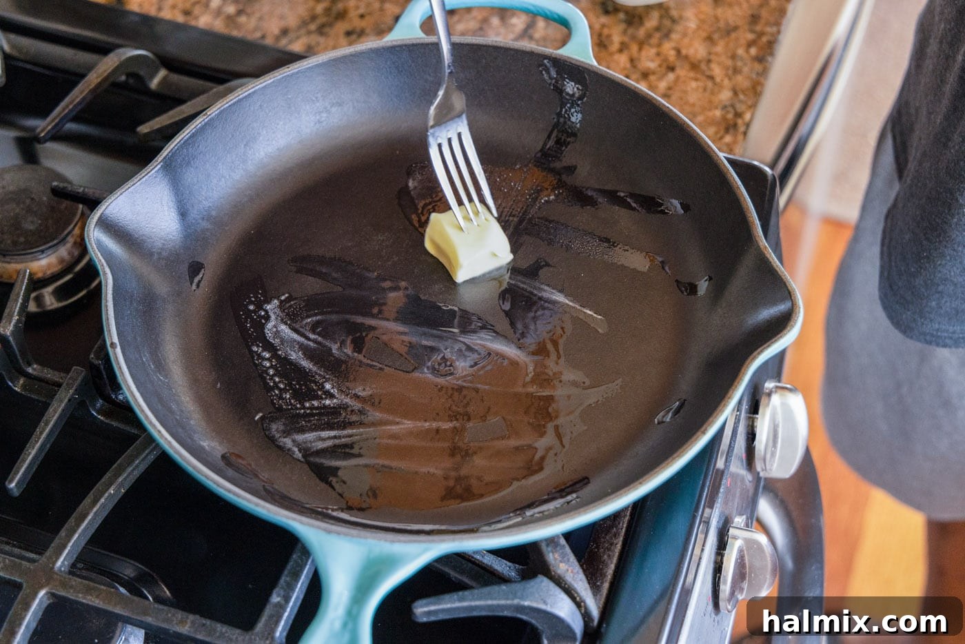 Close-up shot of butter melting and spreading evenly in a hot skillet, ready for frying.