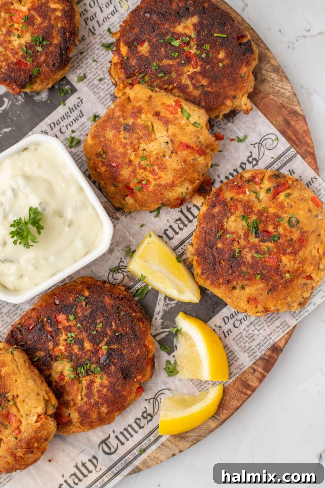 Perfectly pan-fried salmon croquettes resting on parchment paper, showcasing their golden-crisp exterior and readiness to be served.