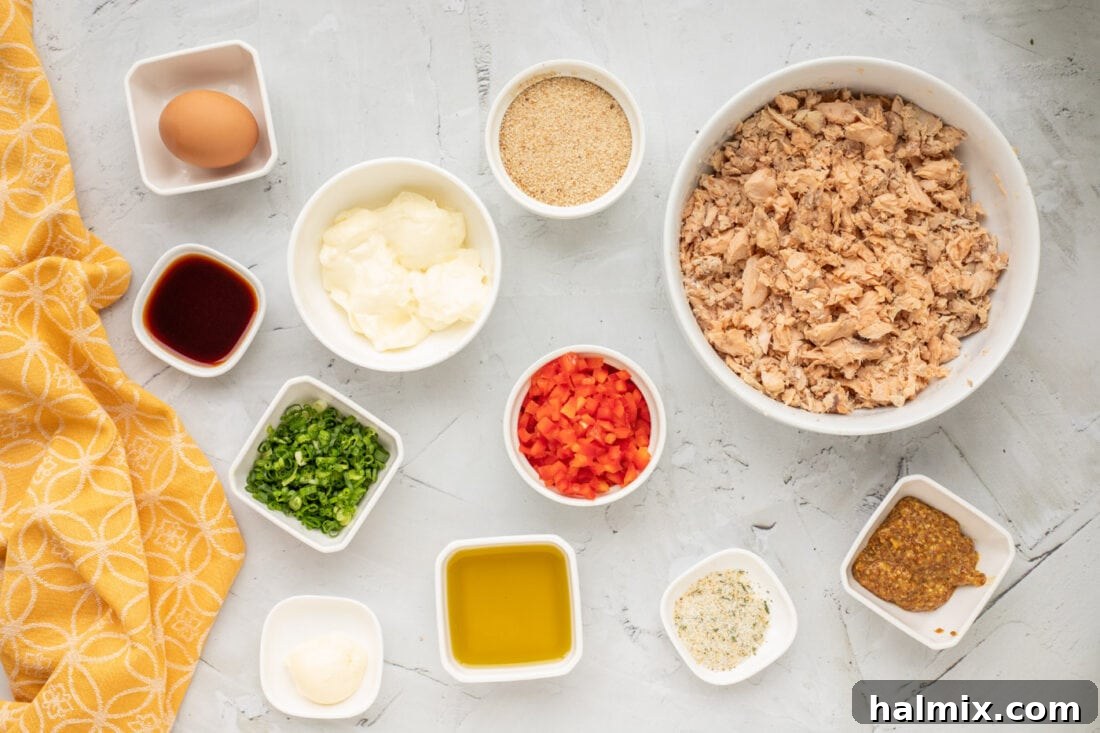 A vibrant display of all the fresh ingredients laid out for making salmon croquettes, including salmon, bell peppers, green onions, and various sauces.