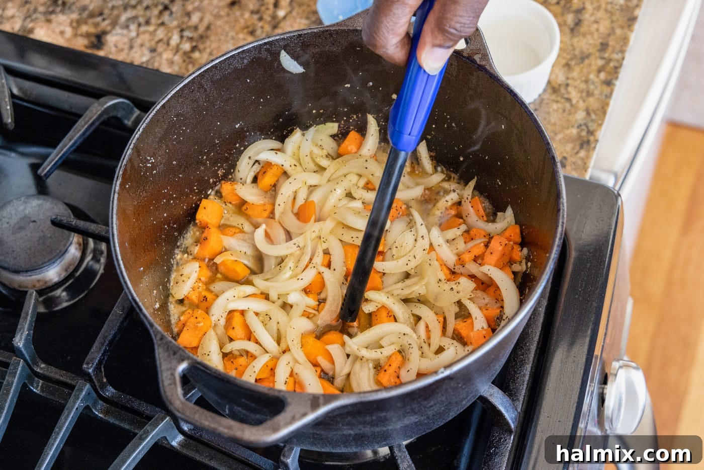 carefully igniting Cognac over the sautéed vegetables in a dutch oven using a long lighter