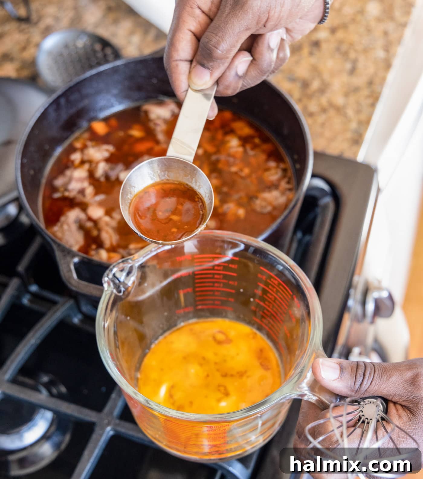 removing pan juices from the Beef Bourguignon stew into a glass measuring cup to make a thickening slurry