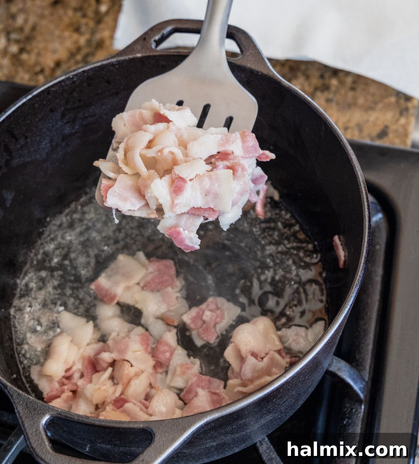 removing soft, rendered bacon from the dutch oven with a slotted spoon