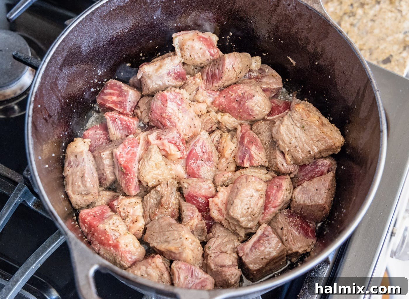 beautifully browned beef chuck cubes searing in a dutch oven, creating a rich crust