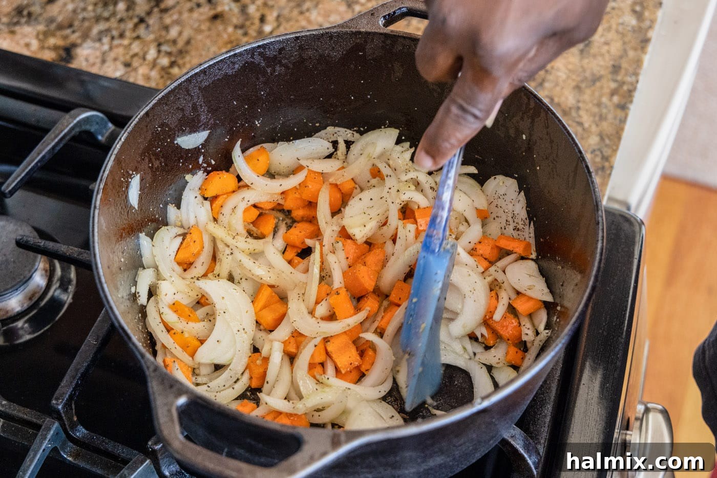 sliced onions, minced garlic, and diced carrots sautéing in a dutch oven, building the aromatic base for the stew