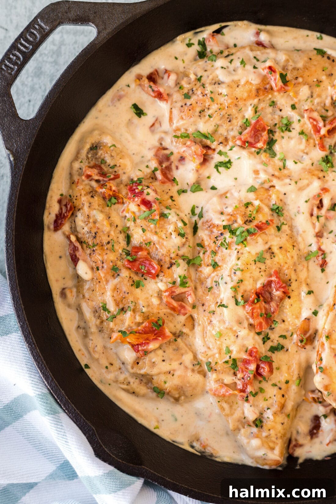Golden-seared Marry Me Chicken in a skillet, garnished with fresh herbs.