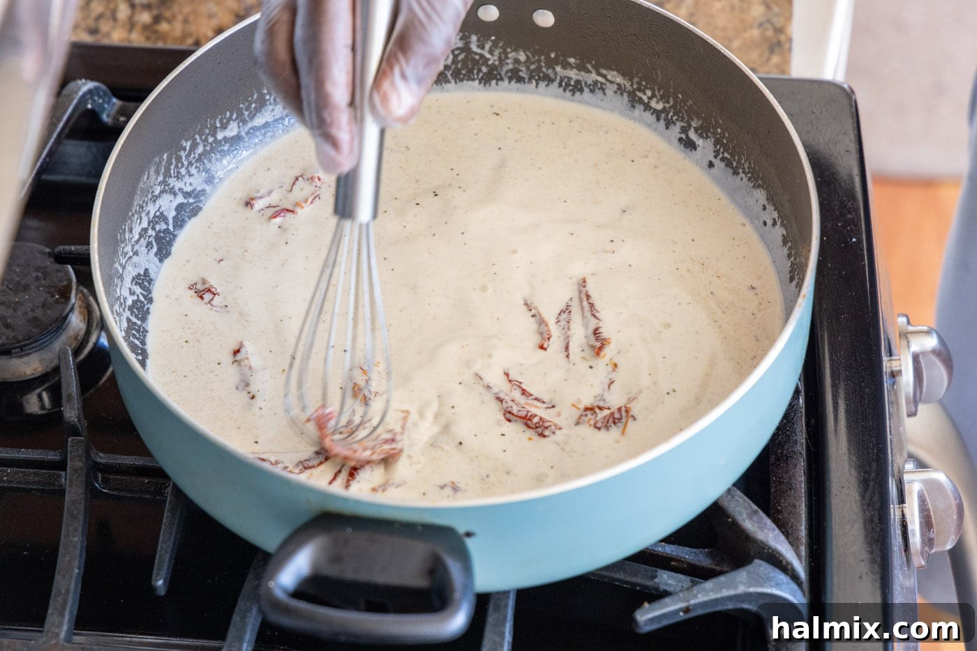 Whisking the heavy cream mixture in a skillet.