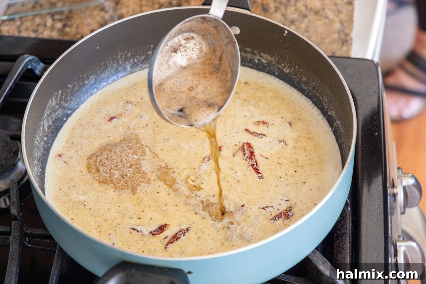 Adding reserved butter and oil mixture to heavy cream in a skillet.