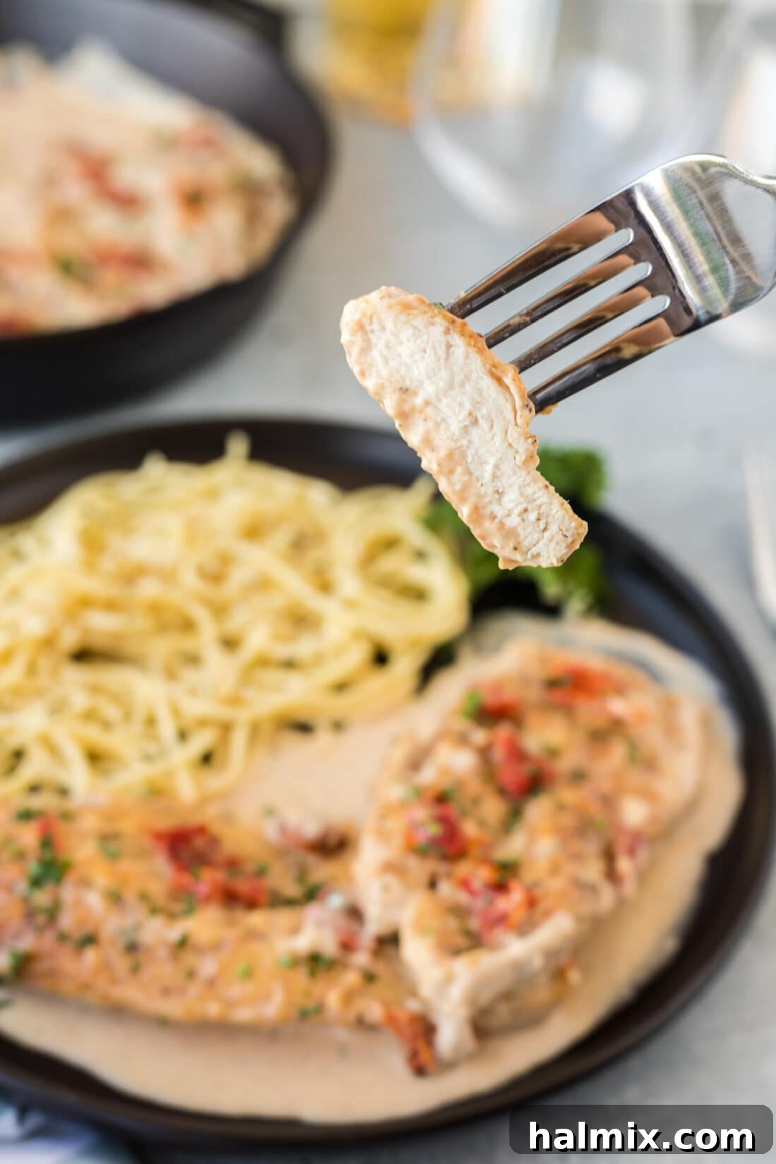A forkful of Marry Me Chicken, showcasing its creamy sauce and tender texture.