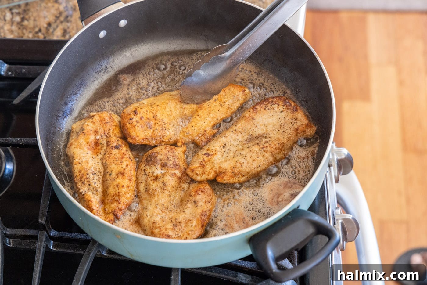 Golden brown cooked chicken breasts in a skillet.