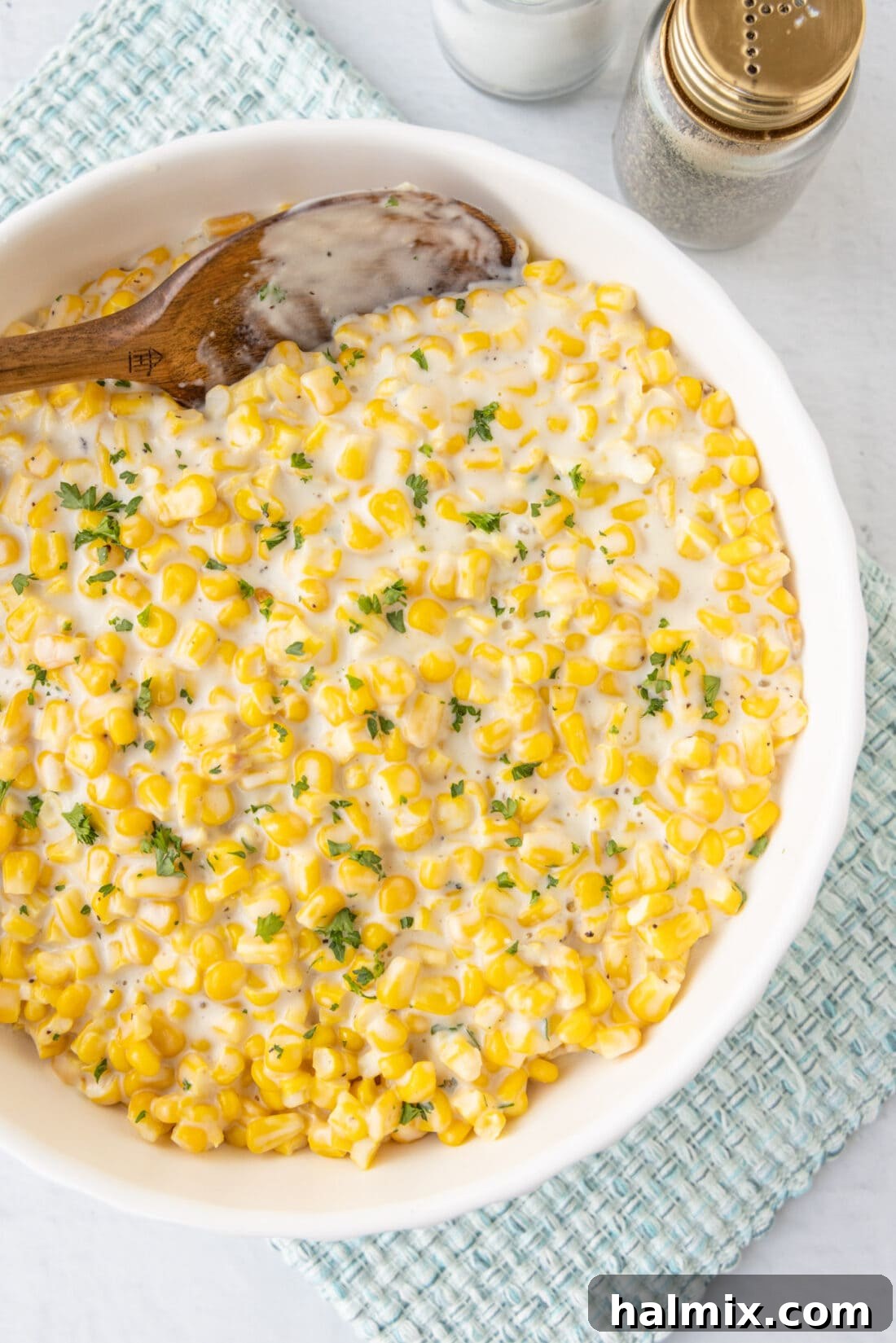 A beautiful bowl of homemade creamed corn, garnished with fresh herbs, ready to be served as a delightful side dish.