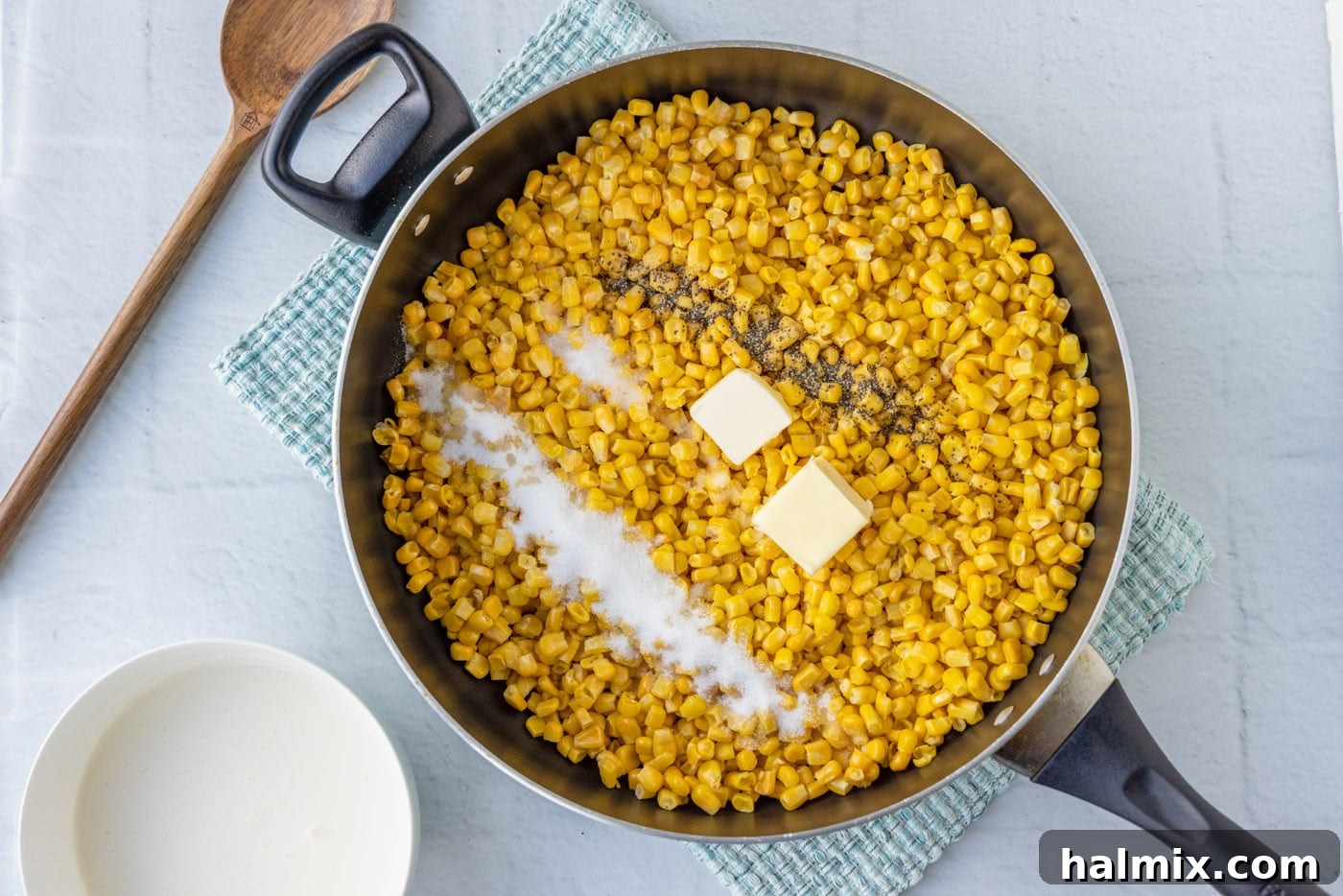 corn, butter, salt, and pepper in a skillet, ready to be cooked