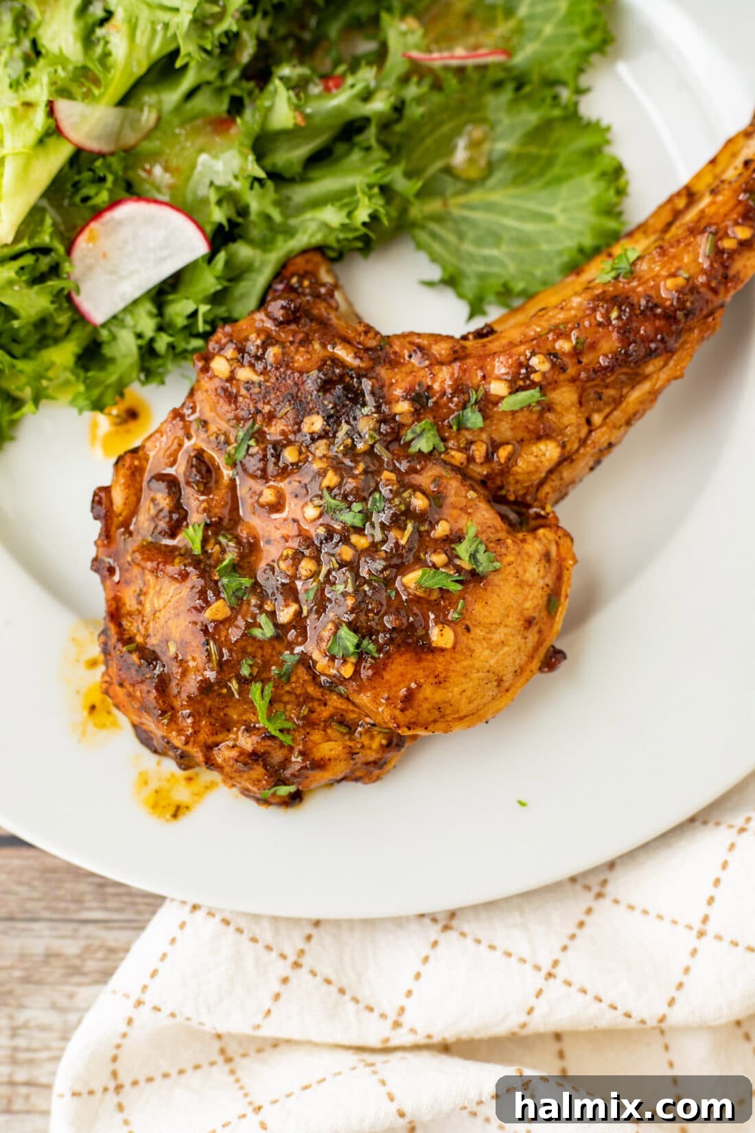 Perfectly seared veal chop served on a plate with a fresh green salad, highlighting its golden crust and juicy interior.