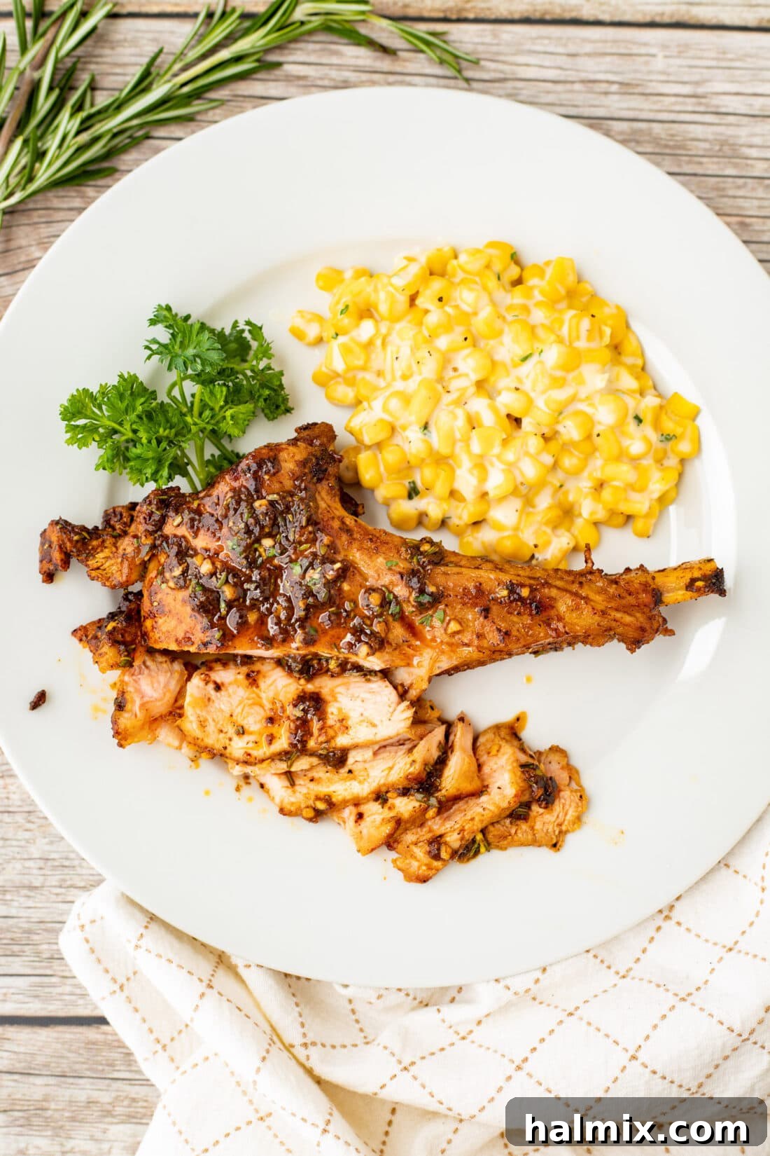 A beautifully plated veal chop accompanied by a side of creamy corn, ready to be enjoyed.