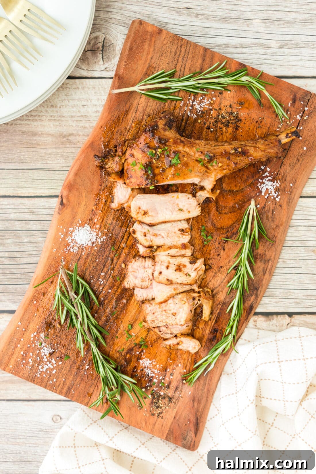 Close-up of a perfectly cooked veal chop resting on a wooden cutting board, showcasing its tender texture.
